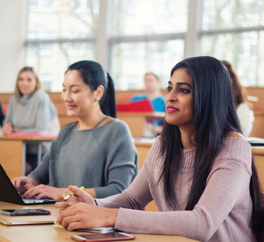A side view of engaged students looking at the front of the classroom
